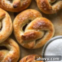 Overhead view of soft baked pretzels next to a dish of salt.