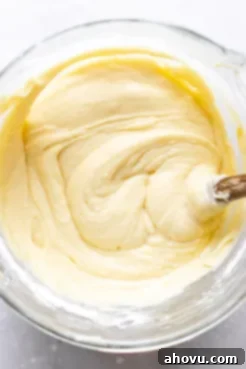 An overhead shot of the perfectly smooth and creamy pound cake batter resting in a clear glass mixing bowl, ready to be transferred to a Bundt pan for baking.