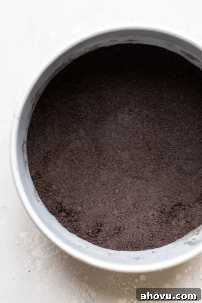 Overhead view of an Oreo crust packed into the bottom of a springform pan. 
