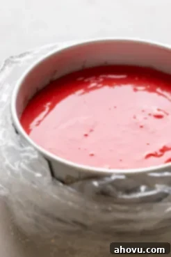 A springform pan wrapped in an oven bag and filled with red velvet cheesecake batter.