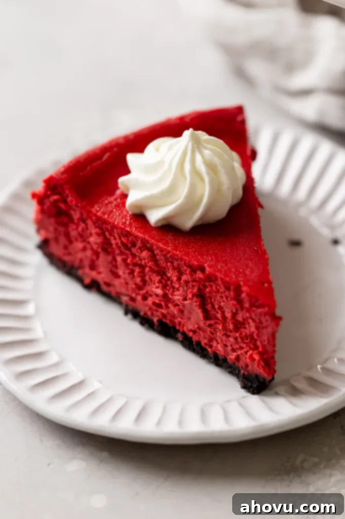 A slice of red velvet Oreo cheesecake on a white dessert plate. 
