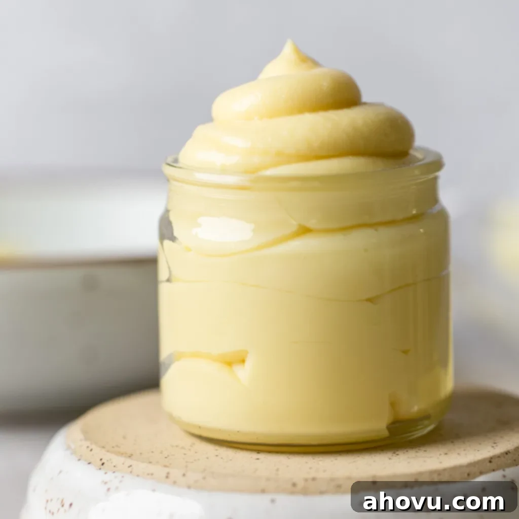 Perfect Homemade Pastry Cream 6 A straight-on view of beautifully prepared pastry cream held in a clear glass jar, sitting atop an overturned bowl, ready for use.