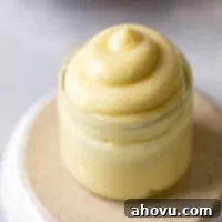 Perfect Homemade Pastry Cream 7 A small glass jar filled with rich vanilla pastry cream, artfully placed on an overturned bowl, highlighting its creamy texture.