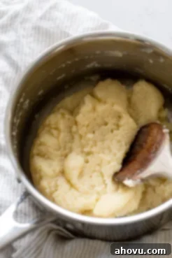 Overhead view of choux pastry dough in a large saucepan.
