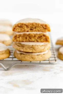 A stack of iced maple cinnamon cookies on a wire rack. Warm, spiced cookies with a sweet maple glaze, perfect for fall.