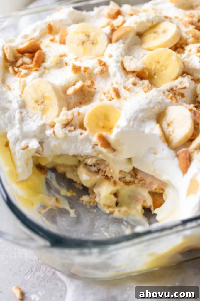 A close up view of a Nilla Wafer banana pudding in a glass dish. A generous serving has been scooped out of the dish. 