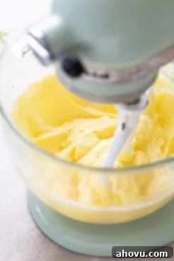 A process shot showing butter, sugar, and eggs expertly mixed together in a stand mixer, forming a creamy and light base for the cake batter.