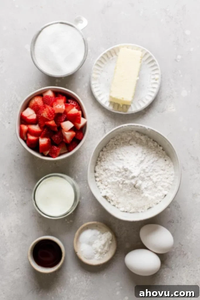 An overhead view showcasing all the fresh and pantry ingredients meticulously laid out for making the strawberry cupcakes and their accompanying strawberry frosting.