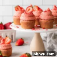 A side view of fresh strawberry cupcakes on a cake stand.