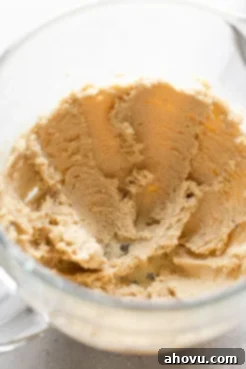 A glass mixing bowl of butter and sugar that's been creamed together.