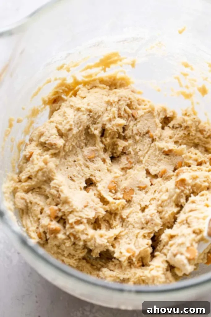 Golden Butterscotch Bites 4 A glass mixing bowl of cookie dough with butterscotch chips in it.