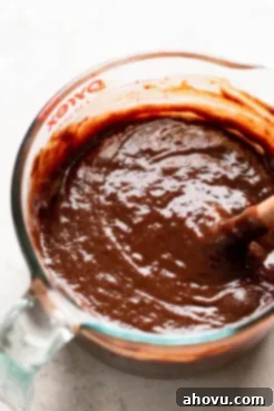 An overhead shot of glossy brownie batter, perfectly mixed in a glass bowl, ready for the next step in baking.