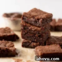 A stack of Nutella brownies on a piece of parchment paper. More brownies surround the stack.