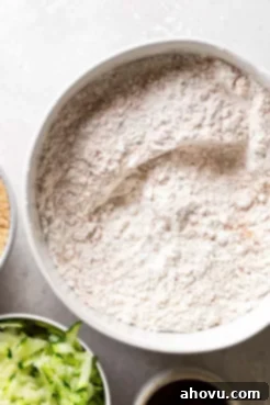 An overhead view of the dry ingredients for zucchini bread muffins in a mixing bowl.