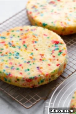 Funfetti birthday cake layers cooling on a wire rack.