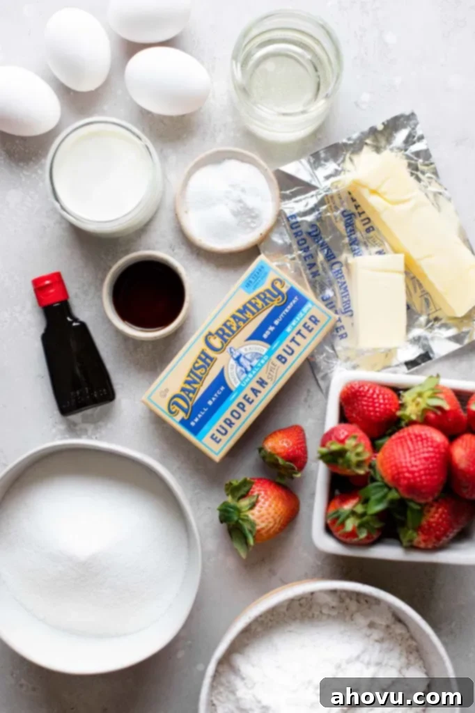 All the essential ingredients for making a delicious strawberry cake neatly arranged on a gray surface.