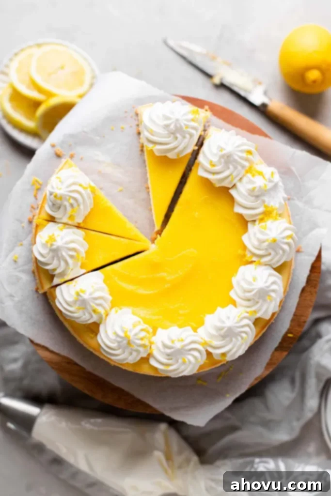 An overhead view of a lemon cheesecake on a cake stand. A few slices have been cut and one is missing. 