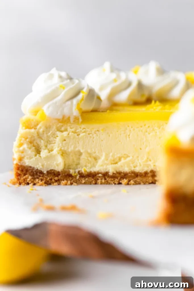 A close-up view of a sliced lemon curd cheesecake, viewed from the side. 