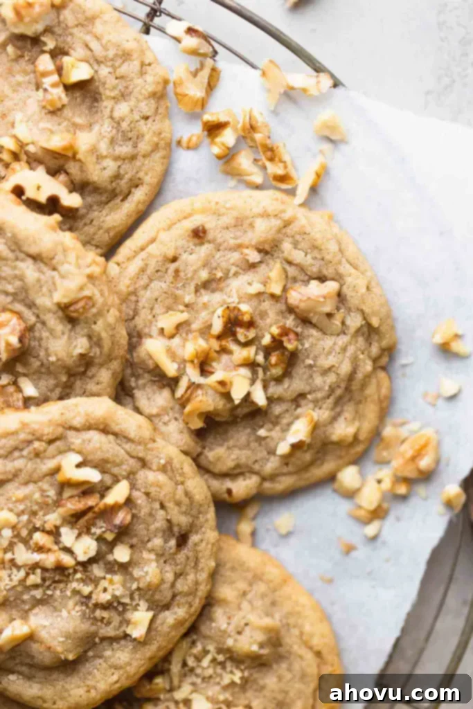 A close-up, inviting overhead view of freshly baked banana nut cookies arranged neatly on a wire cooling rack, highlighting their moist texture and nutty additions.
