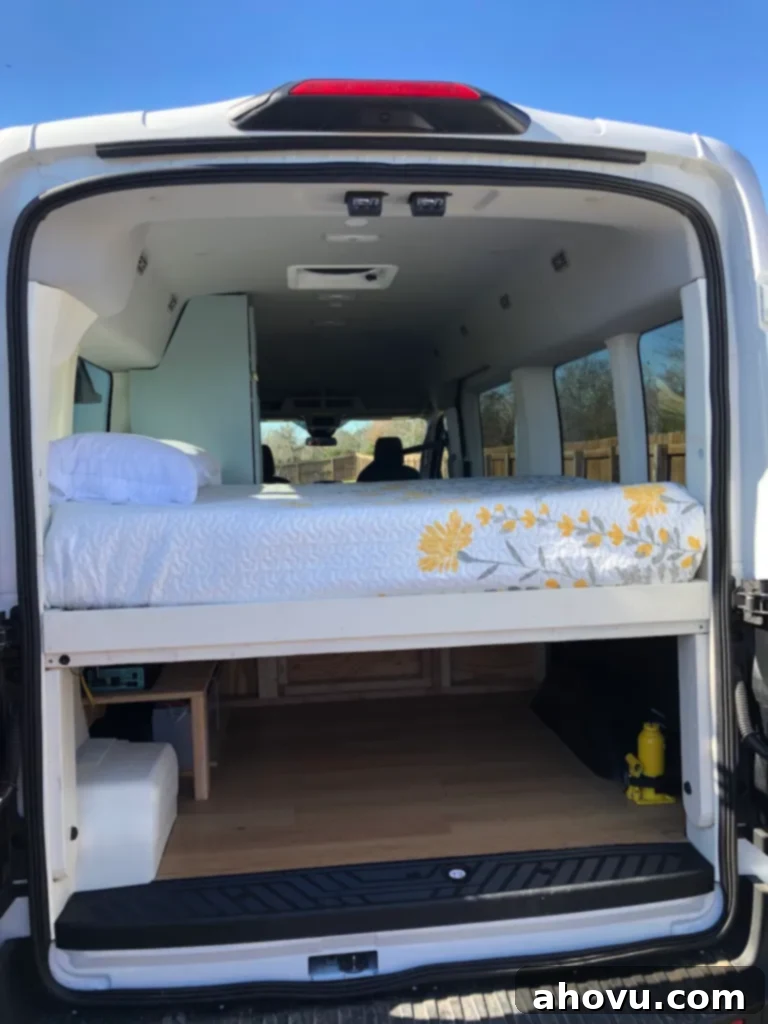 Kitchen Chronicles and Personal News 5 The organized back interior of a renovated cargo van, showcasing ample storage compartments neatly tucked underneath the elevated bed platform, optimizing space for travel essentials.