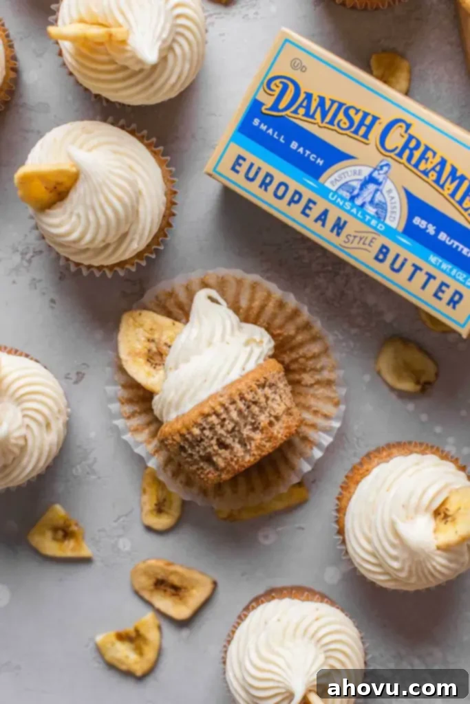 An overhead view of frosted banana cupcakes with a package of Danish Creamery butter. One cupcake is lying on its side. 