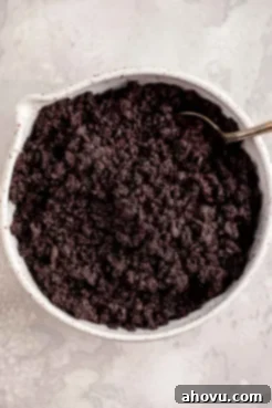 An overhead view of crushed Oreos in a large white mixing bowl.
