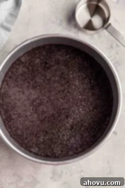 An overhead view of an Oreo cookie crust pressed into a springform pan.