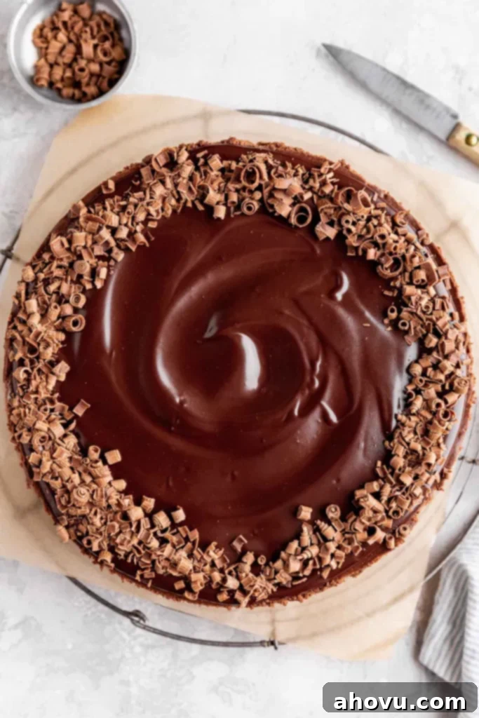 An overhead view of a chocolate cheesecake that's been garnished with chocolate ganache and chocolate shavings. 