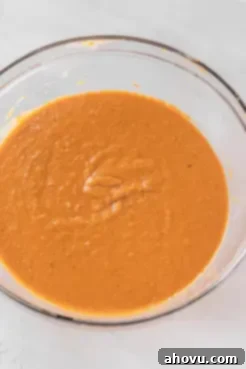 An overhead view of sweet potato pie filling in a glass mixing bowl.