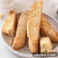 Homemade Almond Biscotti Perfection 6 A few slices of biscotti on a white speckled plate.