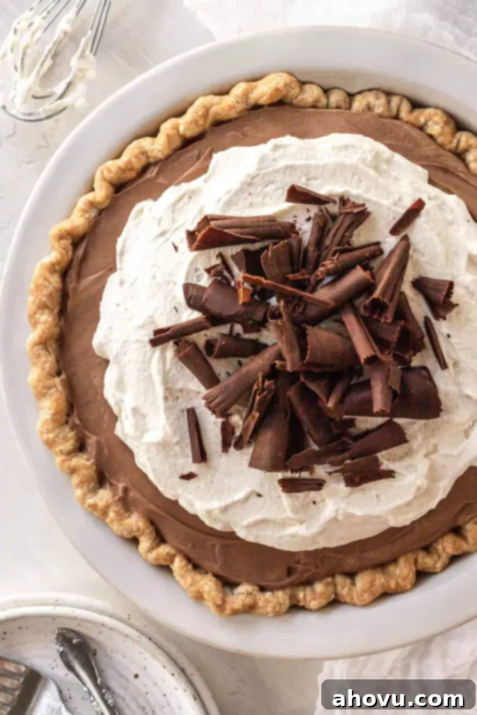 Decadent French Silk Pie 2 An overhead view of a French silk pie garnished with chocolate shavings in a white pie plate.