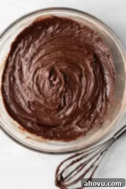 An overhead view of brownie batter mixed together in a glass mixing bowl.