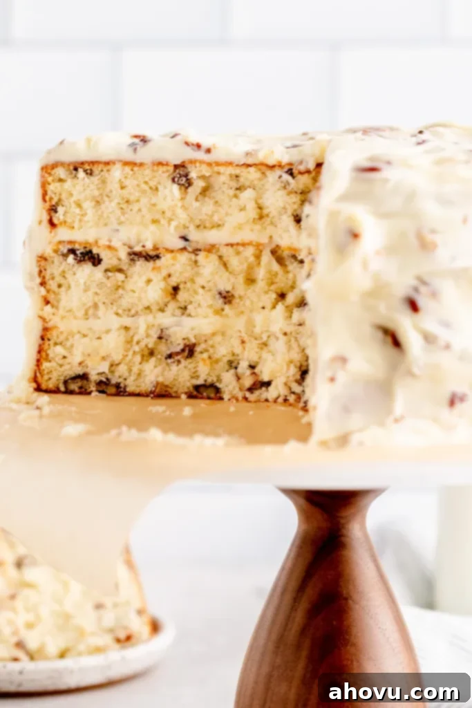 A close-up of an Italian Cream cake that's been sliced to show the texture. A slice of cake and a jug of milk rest in the background.