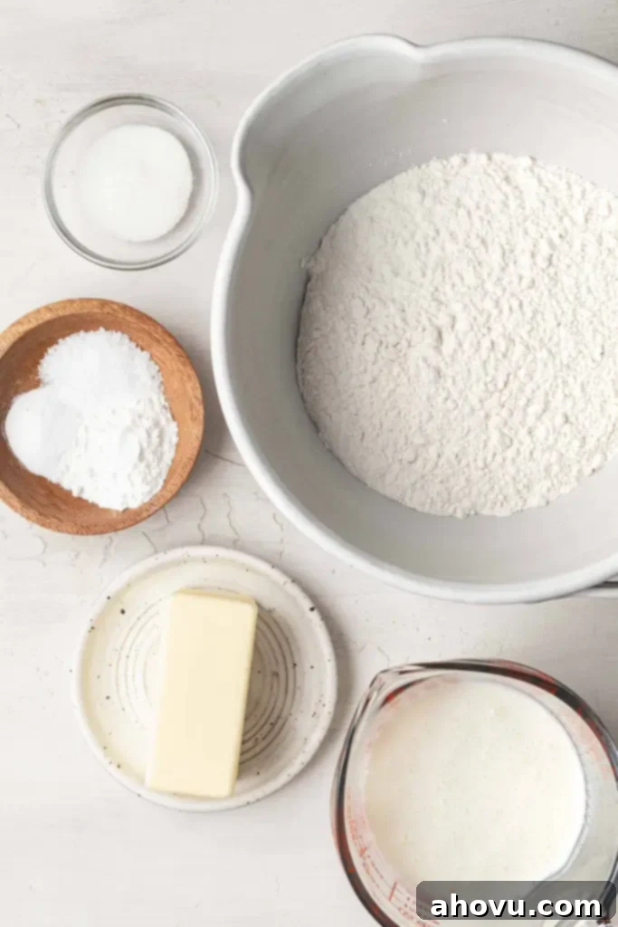 No-Fuss Fluffy Biscuits 3 An overhead view of the essential ingredients laid out for making delicious drop biscuits, including flour, butter, and buttermilk.