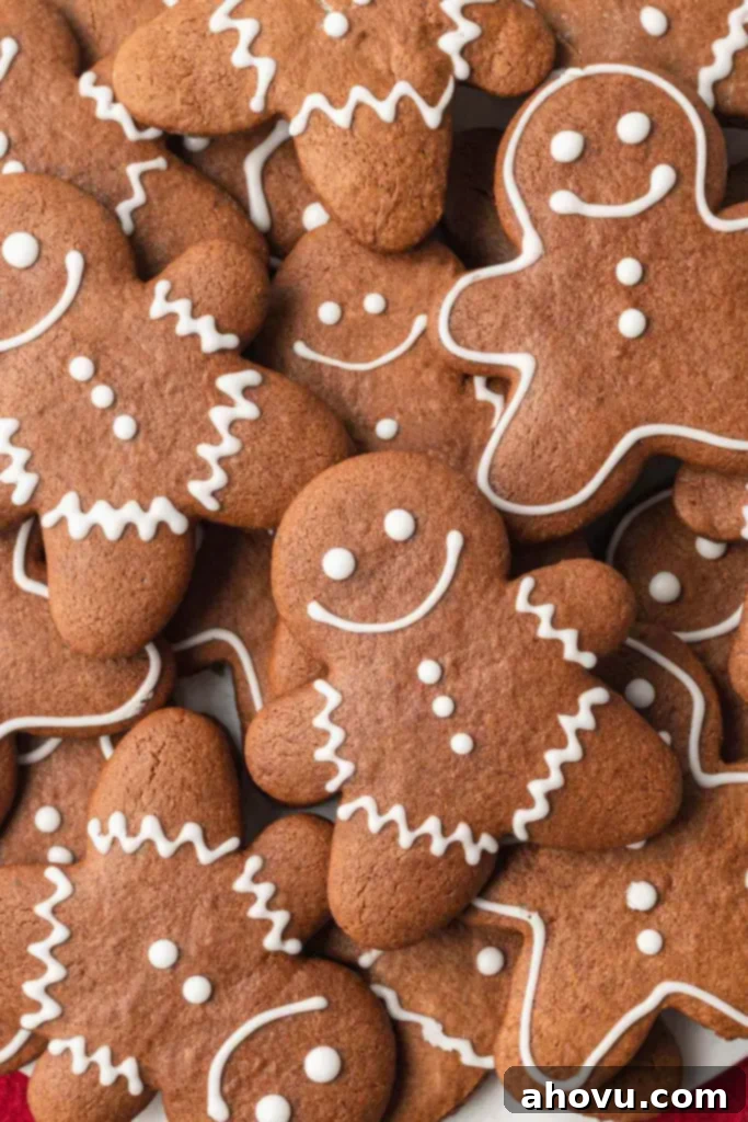 A delightful close-up, overhead view of a tempting stack of freshly baked, perfectly golden-brown gingerbread cutout cookies.