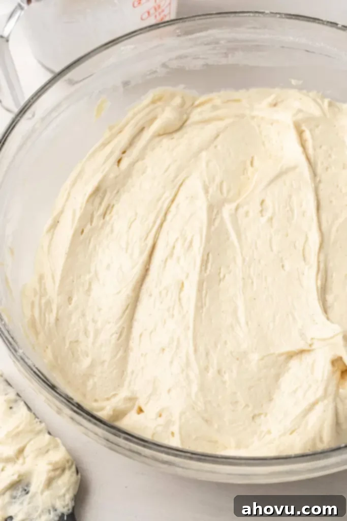 Glazed Cinnamon Honey Bun Cake 4 An overhead view of cake batter in a large glass mixing bowl.