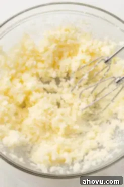 An overhead view of creamed butter and sugar in a glass mixing bowl.