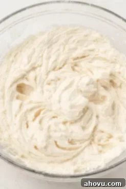 An overhead view of cake batter in a glass mixing bowl.