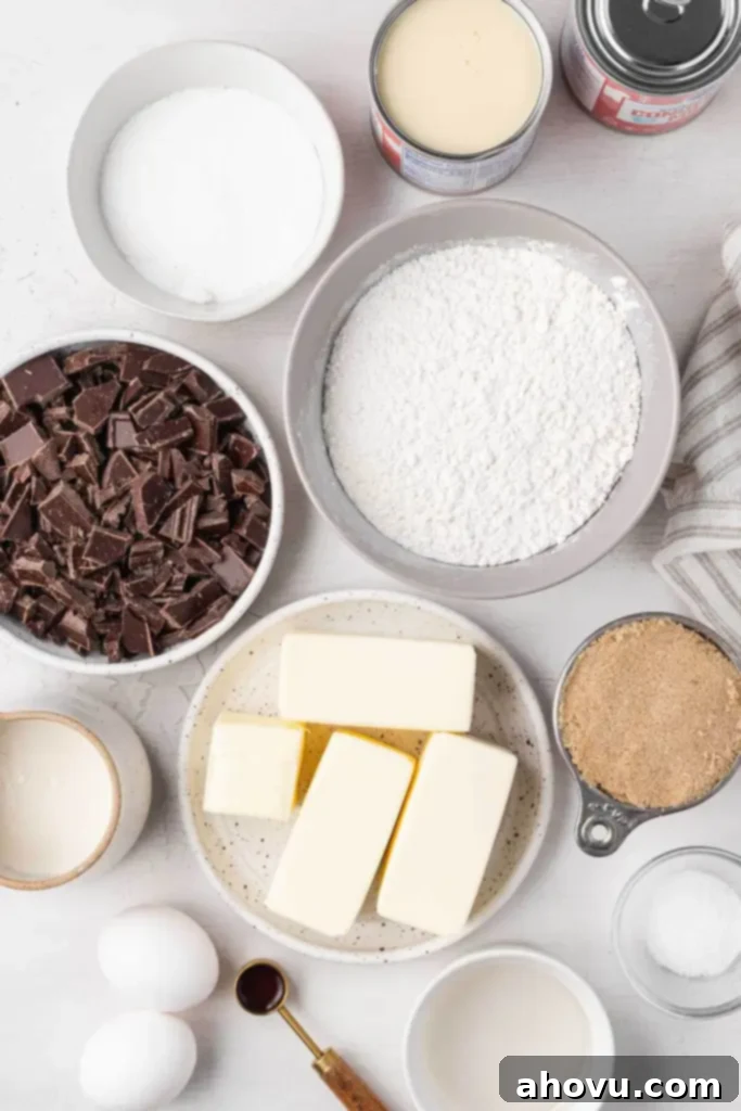 Millionaire Shortbread 3 An overhead view of the essential ingredients laid out for making millionaire shortbread, including butter, flour, sugar, chocolate, and condensed milk.