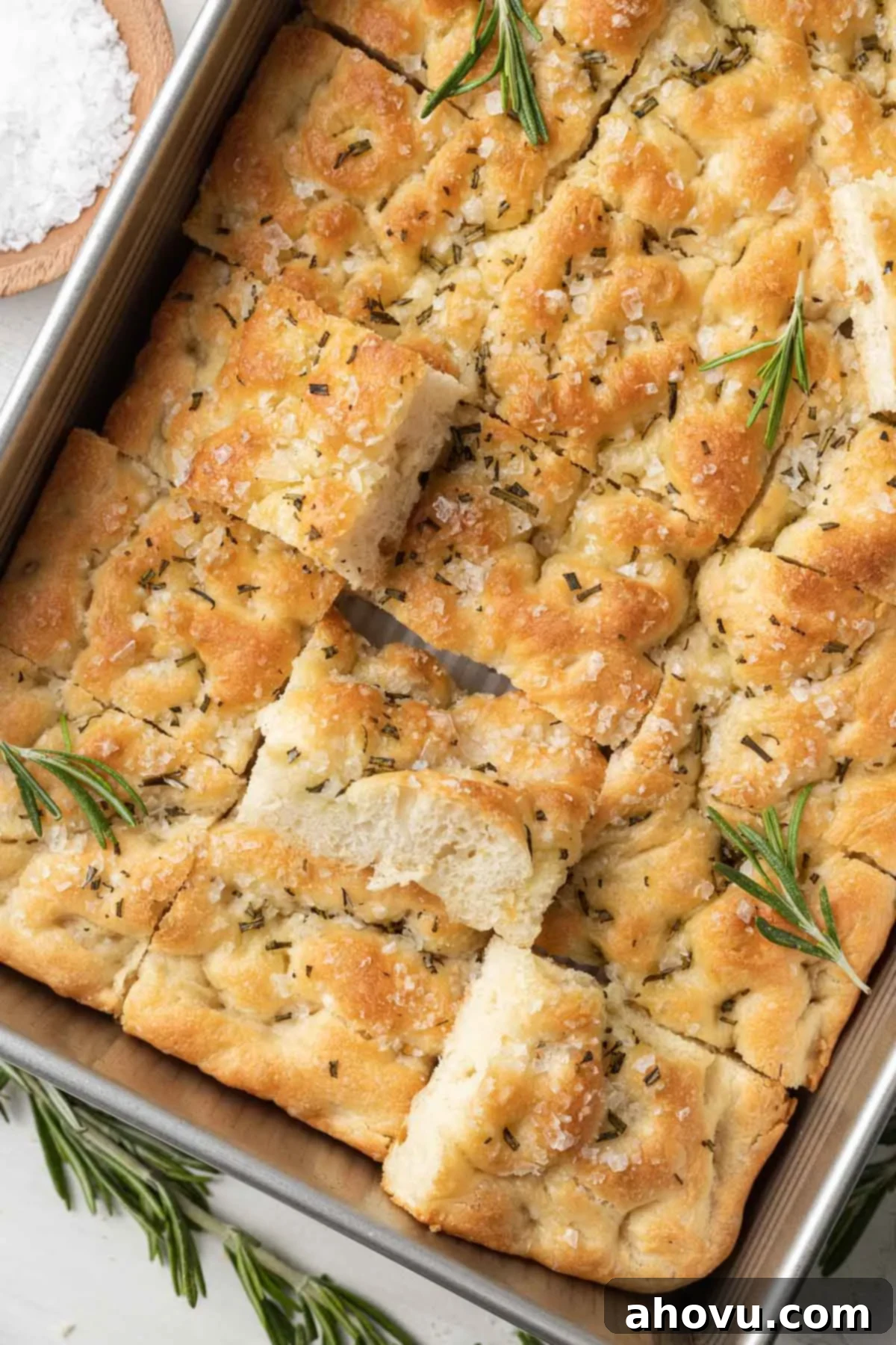 An overhead view of a pan of focaccia bread that's been sliced into pieces.