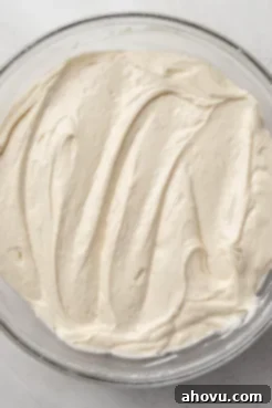 An overhead view of vanilla cake batter in a glass mixing bowl.