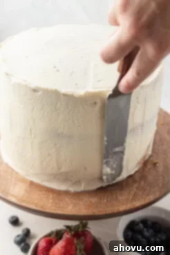 A process shot showing how to frost the outside of the cake.