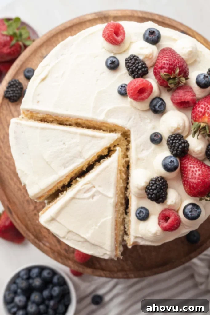 An overhead view of a Chantilly berry cake, with two slices cut out. 