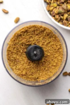An overhead view of crushed pistachios in a food processor.