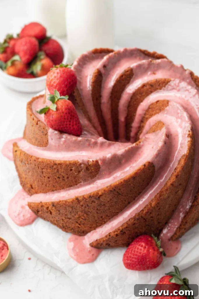 A glazed strawberry pound cake, garnished with fresh berries. 