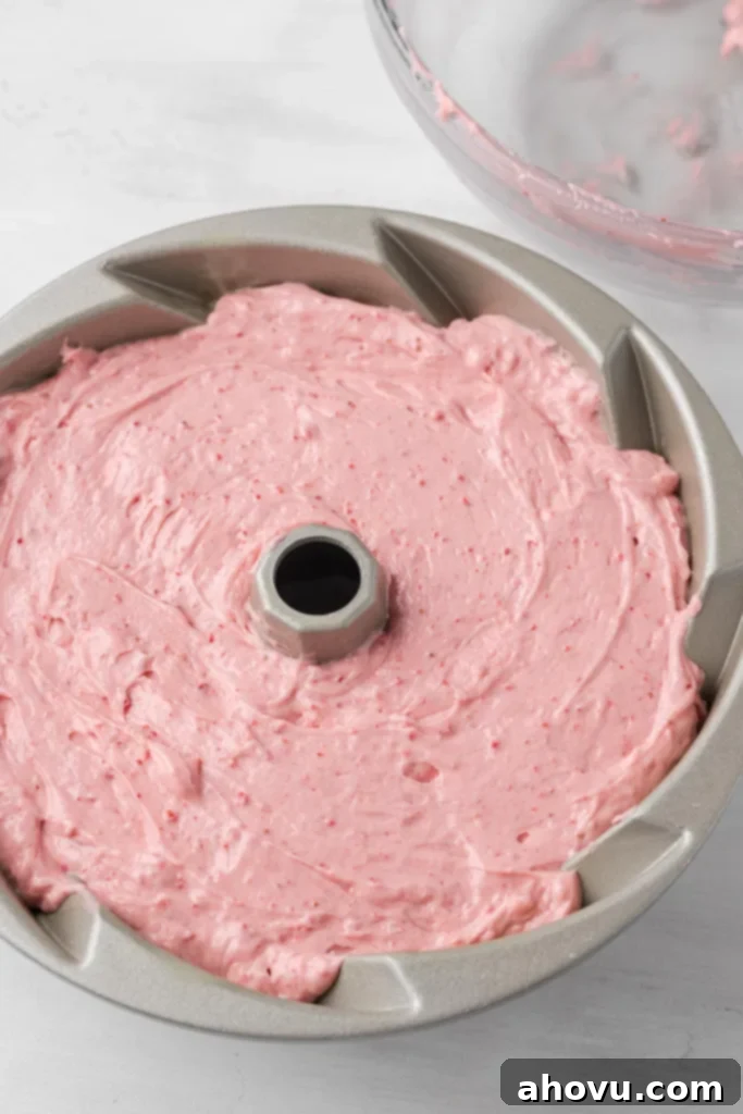 Strawberry pound cake batter in a metal bundt pan. 