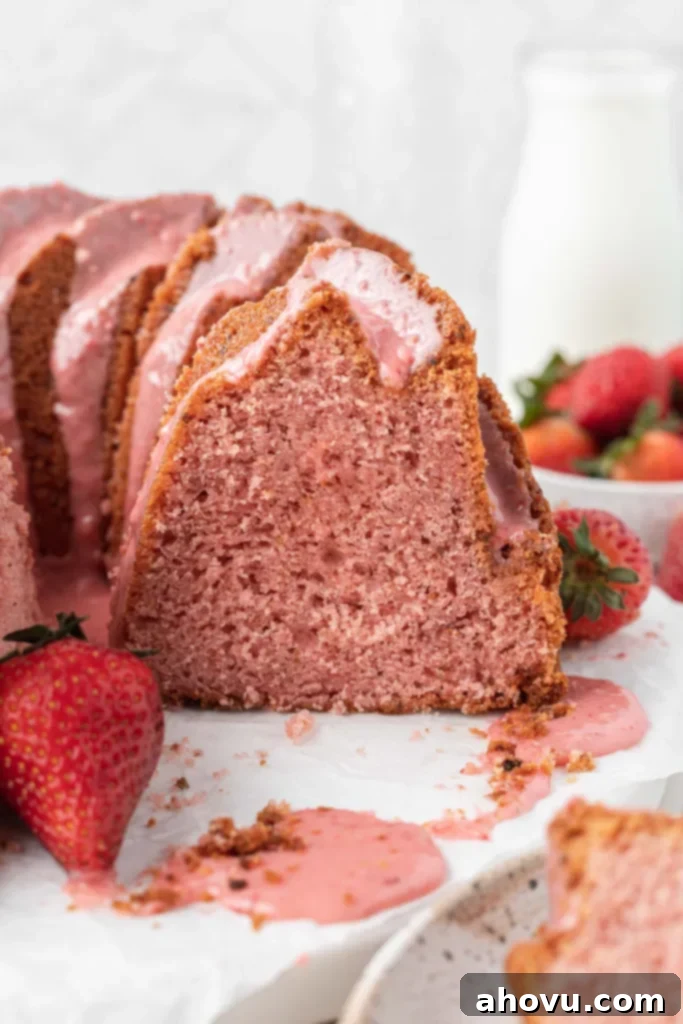 A side view of a sliced pound cake with strawberry glaze. 