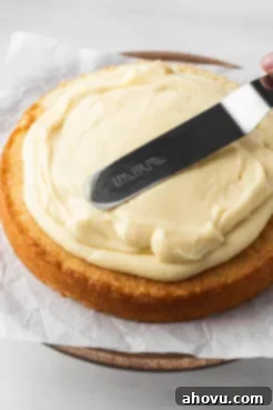 Pastry cream being spread over a sponge cake layer.