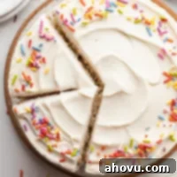 An overhead view of a festive 6-inch vanilla cake topped with colorful sprinkles.