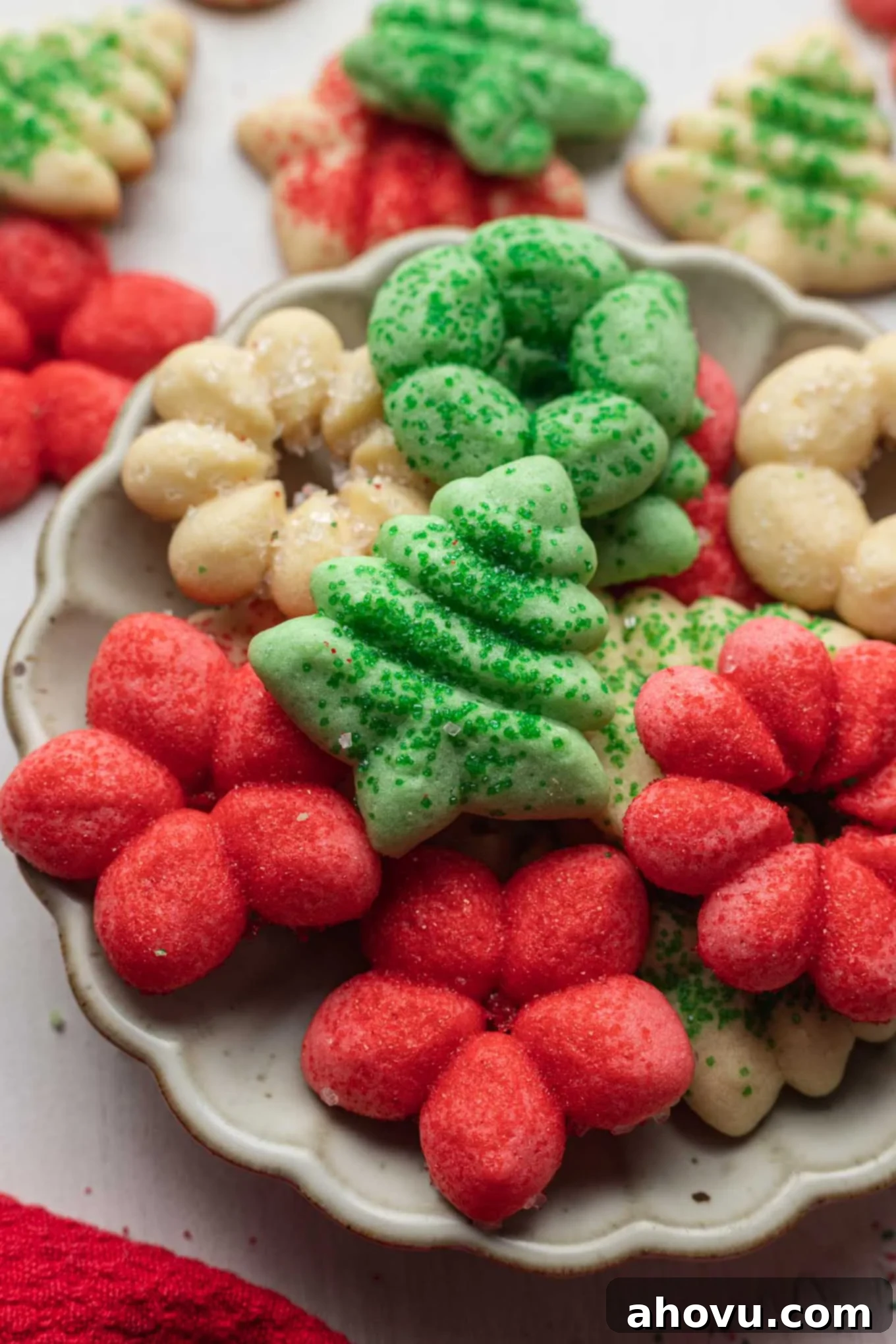 A serving dish of butter spritz cookies, with more cookies in the background. 